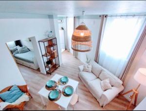a living room with a couch and a table at Plage & Confort Appartement 3 pièces Parking clim et wifi in Antibes