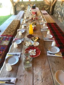 a long wooden table with plates of food on it at Vikendice Suvo Do in Berane