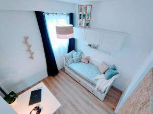 Cette petite chambre comprend un canapé et une table. dans l'établissement Plage & Confort Appartement 3 pièces Parking clim et wifi, à Antibes