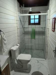 a bathroom with a shower with a toilet and a sink at Casa Agradável, 50m da Praia Freguesia do Ribeirão da Ilha in Florianópolis