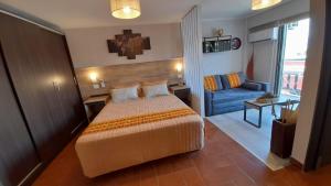 a hotel room with a bed and a blue couch at Departamento Céntrico 2cuadras peatonal tango 07 in San Fernando del Valle de Catamarca