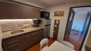 a kitchen with a sink and a counter with chairs at Departamento Céntrico 2cuadras peatonal tango 07 in San Fernando del Valle de Catamarca