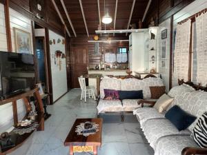 sala de estar con sofá y mesa en Casa Agradável, 50m da Praia Freguesia do Ribeirão da Ilha, en Florianópolis