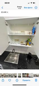 a kitchen with a sink and a shelf with food at Cozy holiday home in Yerevan