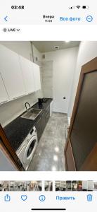 uma cozinha com um lavatório e uma máquina de lavar roupa em Cozy holiday home em Yerevan
