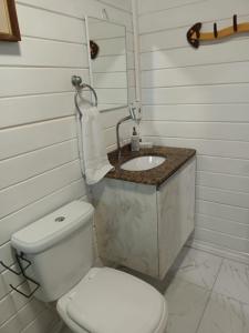 uma casa de banho com um WC branco e um lavatório. em Casa Agradável, 50m da Praia Freguesia do Ribeirão da Ilha em Florianópolis