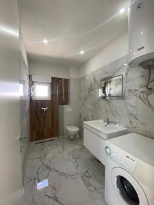 ein Badezimmer mit einem Waschbecken und einer Waschmaschine in der Unterkunft Apartments Arjan2 in Omiš