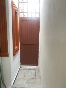 a red door in a white wall with a window at Prívate and quiet. in Chihuahua