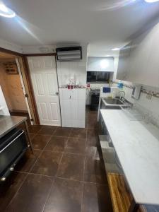 a kitchen with white cabinets and a tile floor at Valpo Arte in Valparaíso