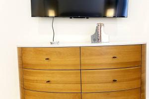 un tocador de madera con TV encima en Historic DTWN Hotel, The Phenix, King Bed, Room # 303, en Bangor