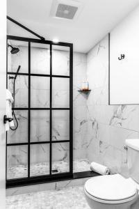 a bathroom with a toilet and a glass shower at Historic DTWN Hotel, The Phenix, King Bed, Room # 303 in Bangor