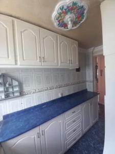 a kitchen with white cabinets and a blue counter top at Departamento Amoblado en Quito Norte, sector la Udla Universidad Av Granados in Quito