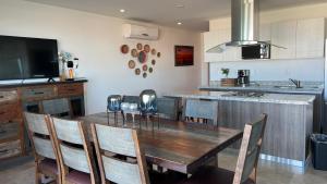 a kitchen with a wooden table with chairs and a television at Mar Laguna Hotel in Mazatlán