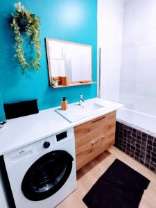 La salle de bains est pourvue d'un lave-linge et d'un lavabo. dans l'établissement Plage & Confort Appartement 3 pièces Parking clim et wifi, à Antibes
