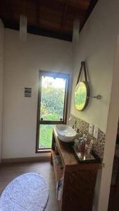 a bathroom with a sink and a window at Chalé Canto da Montanha in Serra do Cipo