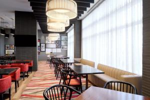 a restaurant with tables and chairs and a large window at Residence Inn by Marriott Montreal Airport in Dorval