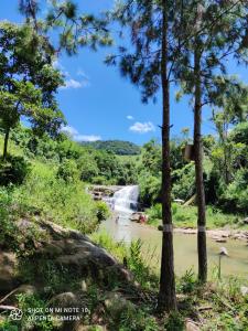 a waterfall in the middle of a river with trees at Casa Muro Alto-Sana Rj in Macaé