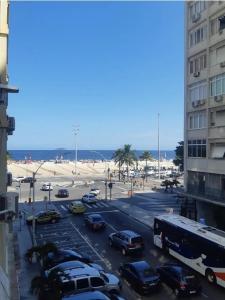 a busy city street with cars and a beach at Lev Apartments - Apto Beira-Mar - Posto 2 - Copacabana in Rio de Janeiro