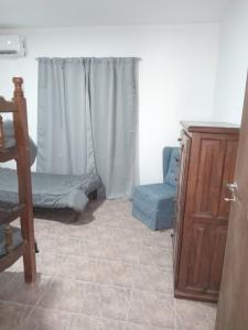Zimmer mit einem Bett, einem Fenster und einem Stuhl in der Unterkunft JOAQUINA in Ramallo