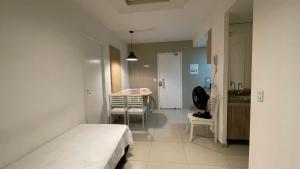 a room with a bed and a table and a kitchen at Apart Vg Fun in Fortaleza