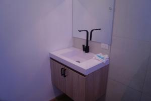 uma casa de banho com um lavatório e um espelho em Casita Marlín Quepos em Quepos
