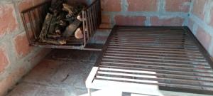 a bed in a brick room with a shelf with logs at MONOAMBIENTE en HOSTERIA LAS LUCES in San Blas