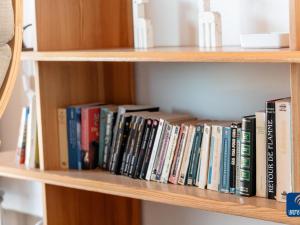 a row of books on a book shelf at Apartment on Belgian Coast with Sea View in De Haan