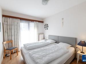 uma grande cama branca num quarto com uma janela em Blomme 0103 Apartment on the seafront em De Haan