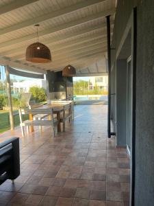 une terrasse avec une table, une table et des bancs dans l'établissement Casa Curutchet, à Cañuelas