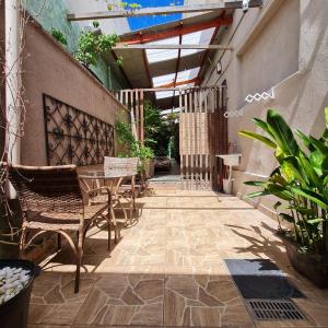 a patio with a table and chairs and plants at Pousada - Aqui Hostel in Bragança Paulista