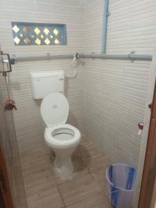 a bathroom with a white toilet in a stall at J Rooms&Dormentary in Madurai