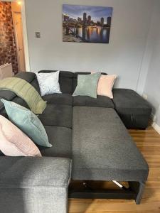 - un salon avec un canapé gris et des oreillers dans l'établissement Walk to the city center!, à Derry Londonderry