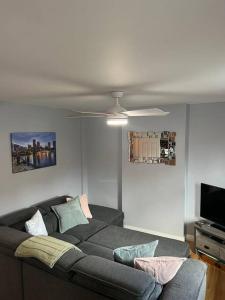 a living room with a couch and a ceiling fan at Walk to the city center! in Derry Londonderry