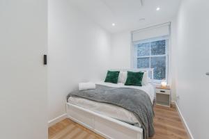 a white bedroom with a bed and a window at Cosy 2 Bedroom Flat in Lake District in Kendal