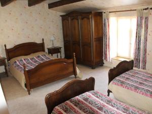 a bedroom with two beds and a wooden cabinet at Gîte confortable à Halles-sous-les-Côtes avec cheminée et terrasse - FR-1-585-5 in Halles-sous-les-Côtes