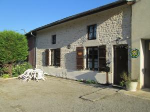 a white brick building with a bench in front of it at Maison cosy avec terrasse, 3 chambres, wifi, animaux acceptés, idéal pour familles en Meuse - FR-1-585-2 in Bréhéville