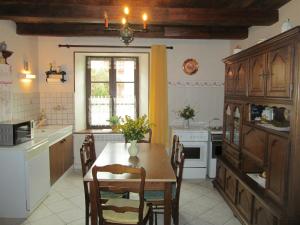 a kitchen with a table and chairs and a window at Maison cosy avec terrasse, 3 chambres, wifi, animaux acceptés, idéal pour familles en Meuse - FR-1-585-2 in Bréhéville