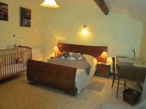 a bedroom with a large bed and a crib at Maison cosy avec terrasse, 3 chambres, wifi, animaux acceptés, idéal pour familles en Meuse - FR-1-585-2 in Bréhéville