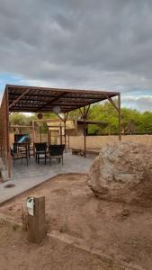 a pavilion with a picnic table and a rock at Cabañas el Chañar in San Pedro de Atacama