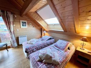 two beds in a room with a attic at Chalet Montagne avec Spa, Sauna & Proche Pistes - Gérardmer - FR-1-589-114 in Gérardmer