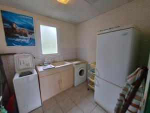 eine Küche mit einem Kühlschrank, einer Waschmaschine und einem Trockner in der Unterkunft Gîte Saint-Mars-sur-la-Futaie, 3 pièces, 4 personnes - FR-1-600-150 in Saint-Mars-sur-la-Futaie