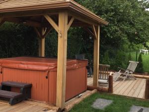 a wooden gazebo with a barbecue on a deck at Chalet Montagne avec Spa, Sauna & Proche Pistes - Gérardmer - FR-1-589-114 in Gérardmer