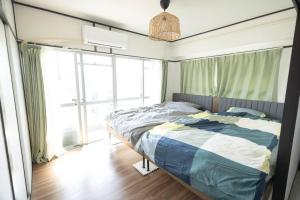 - une chambre avec un lit et une grande fenêtre dans l'établissement NOBEYAMA WIND, à Tokyo