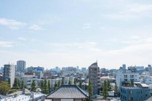 une vue sur les toits d'une ville avec des bâtiments dans l'établissement NOBEYAMA WIND, à Tokyo