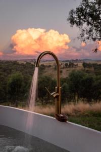 a water hose hooked up to a bath tub with a fountain at Kestrel Nest EcoHut in Mount Adrah