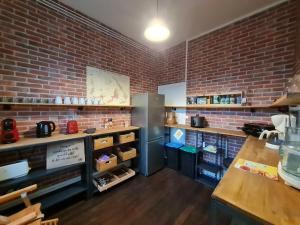 a kitchen with a brick wall and a refrigerator at Maison années 30 avec jardin, piscine, proximité Loire, 4 chambres, vélos, idéale familles/amis - FR-1-590-261 in Bonny-sur-Loire