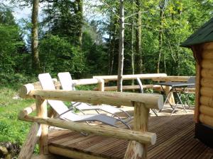 une terrasse en bois avec des chaises et une table de pique-nique dans l'établissement Escapade Romantique: Cabane avec Terrasse Panoramique, Poêle à Bois et Éclairage Multicolore - FR-1-589-441, à Ferdrupt