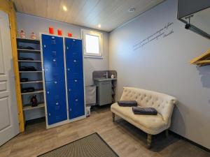 un dressing avec un banc et des casiers bleus dans l'établissement Escapade Romantique: Cabane avec Terrasse Panoramique, Poêle à Bois et Éclairage Multicolore - FR-1-589-441, à Ferdrupt 23 autres photos