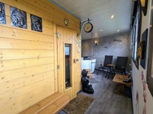 Cette chambre est dotée d'un mur en bois et d'une horloge murale. dans l'établissement Escapade Romantique: Cabane avec Terrasse Panoramique, Poêle à Bois et Éclairage Multicolore - FR-1-589-441, à Ferdrupt
