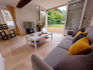 a living room with a couch and a table at Gîte Saint-Poix, 5 pièces, 11 personnes - FR-1-600-212 